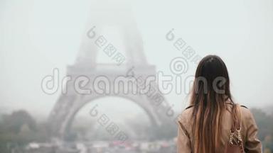 年轻迷人的女人独自在市中心散步，在法国巴黎雾蒙蒙的早晨探索埃菲尔铁塔。